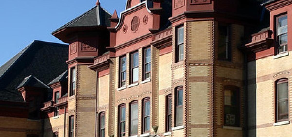 Stock image of Waldo Hall, where some OSU public health researchers have their offices; building is old-fashioned yellow brick with red at the top and black roofs on the spires.