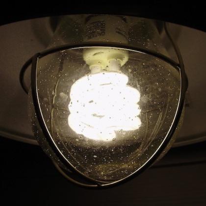 Stock image of a brightly lit light bulb inside a clear glass fixture
