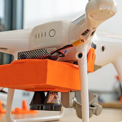 Image of white and orange drone on a countertop. 