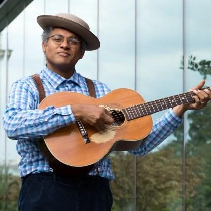Musician Dom Flemons with his guitar