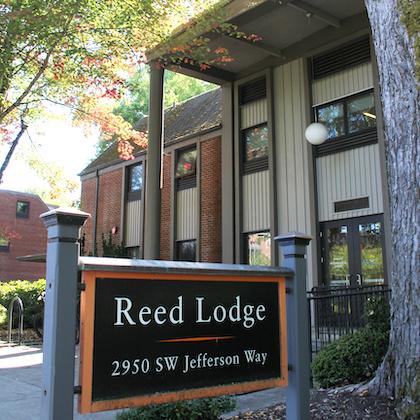 Image shows Reed Lodge on OSU campus, with an orange-and-black sign in the foreground bearing its name.