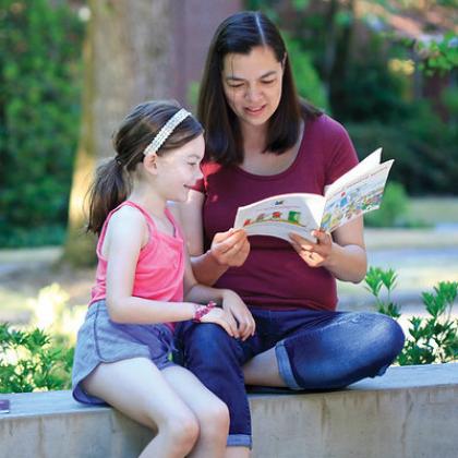 Shauna Tominey reading a book with a child
