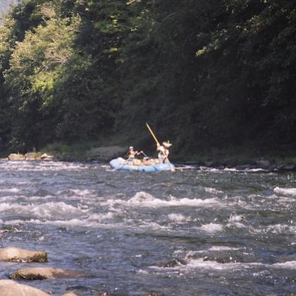 Researchers on a raft testing water quality in a river