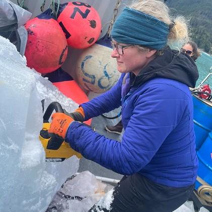 Erin Pettit cuts glacier ice with a chain saw to measure ice structural properties and bubble pressures.