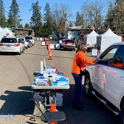 Jan Williams, with the OSU Extension Service in Clackamas County, collects paperwork from participants before they receive their shot at the drive-through COVID-19 vaccination clinic on March 31 in Canby. 
